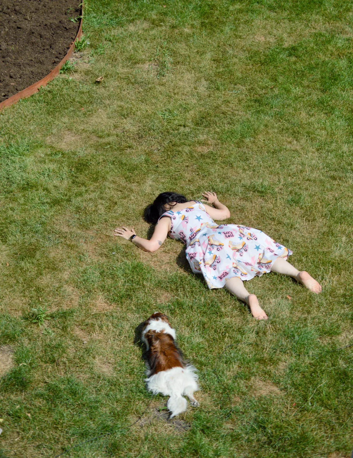 Nira Tal lying on the grass with her dog